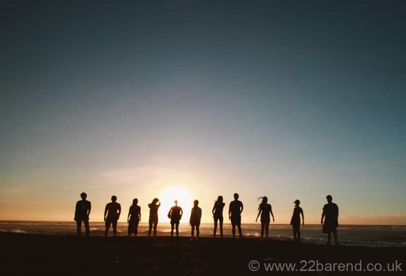 Large line of people silhouetted on a beach