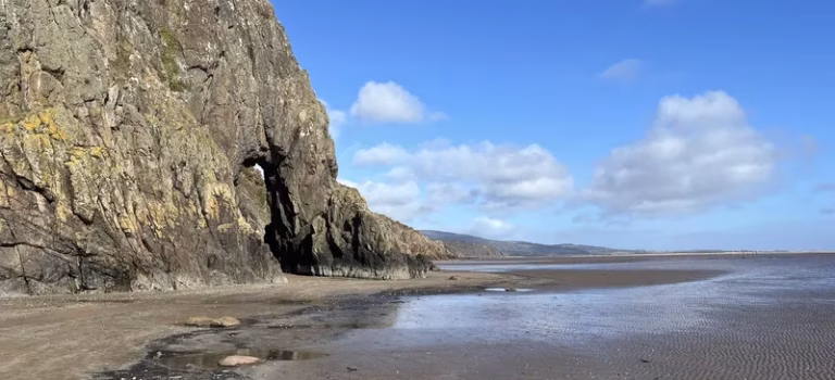Portling Bay Coastal Loop The Needle's Eye natural rock arch near Sandyhills Beach on the Solway Coast, accessible at low tide