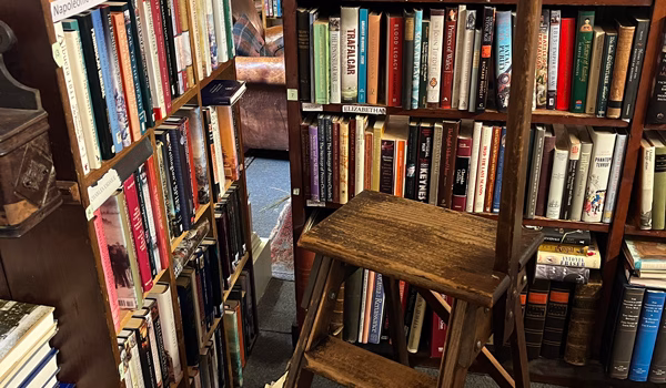 Inside a rambling second-hand bookshop in Wigtown with wooden library steps and floor-to-ceiling bookshelves.
