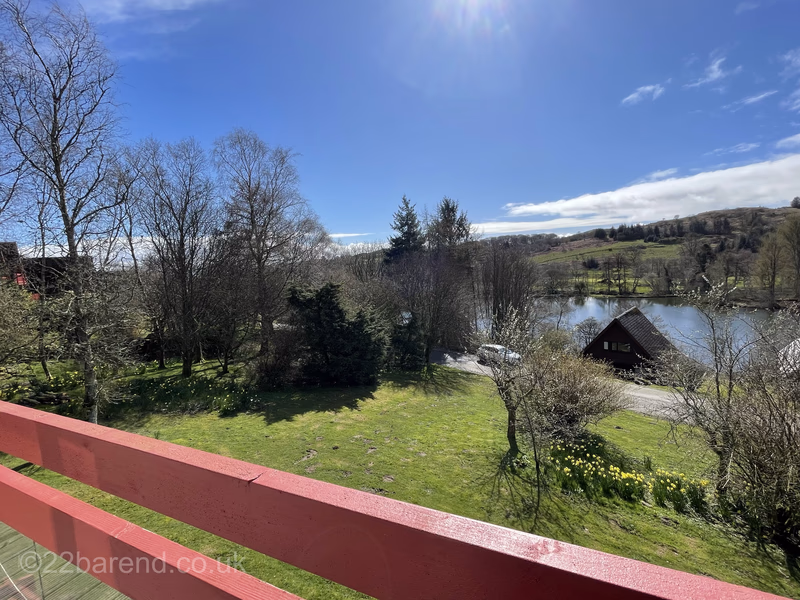 View across the gardens and loch from the balcony of Serenity 22 Barend holiday lodge near Sandyhills in Dumfries & Galloway